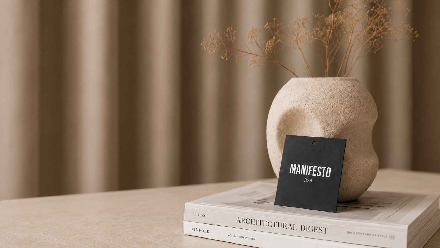 Karta MANIFESTO B2B na książkach obok ceramicznego wazonu